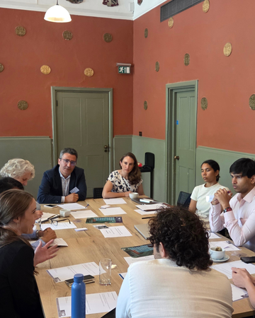 Delegates seated around a table during a group discussion